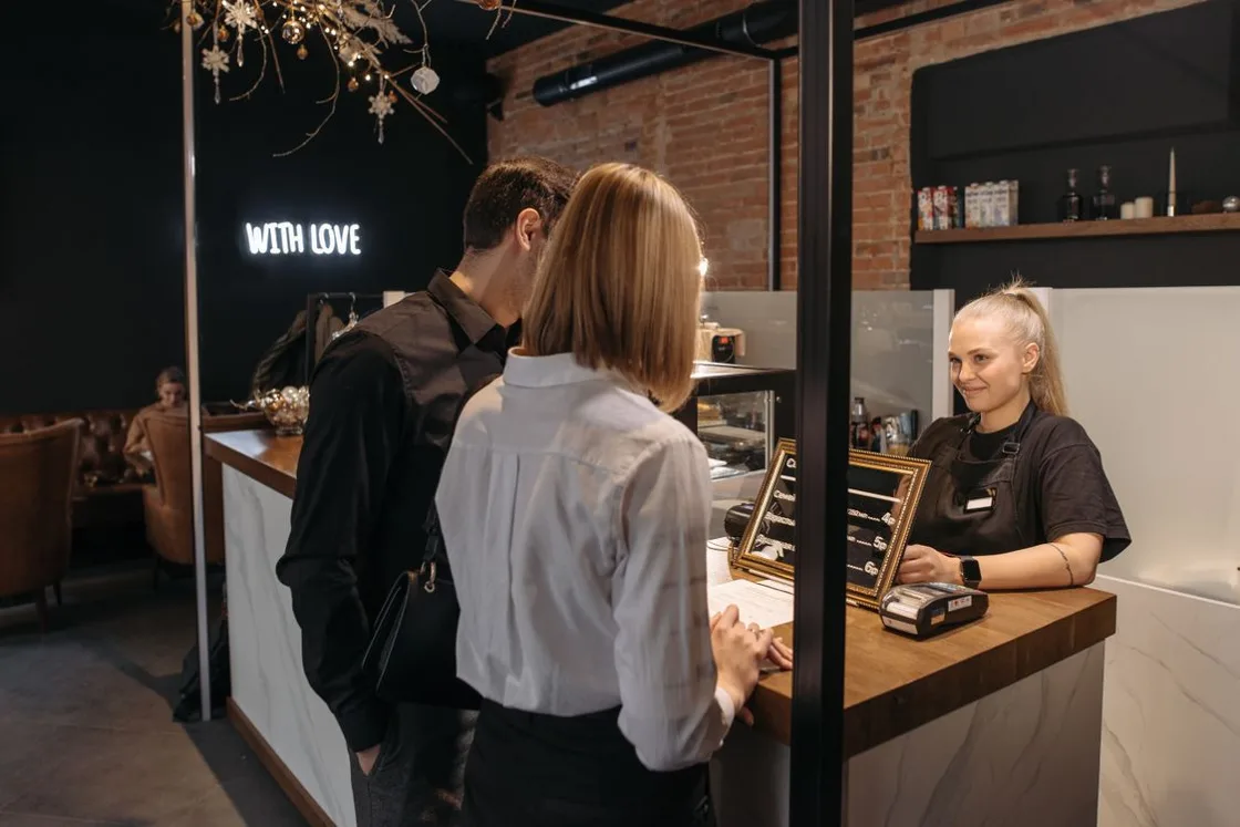 A barista serving customers at a café counter